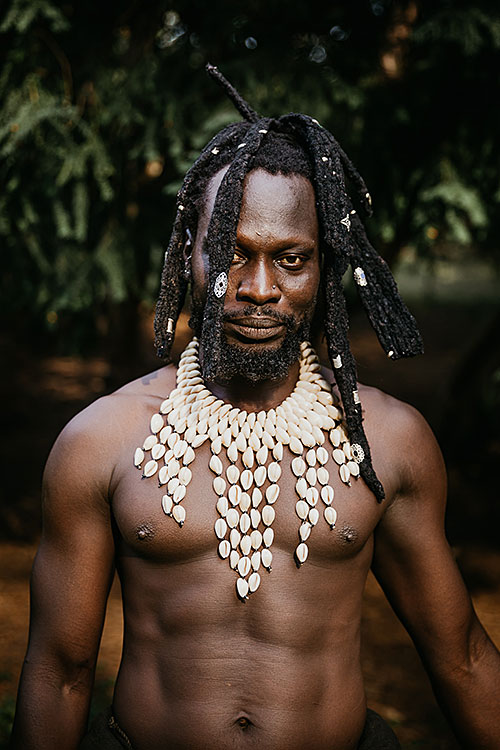 dancer kaolak with tribal jewelry and no shirt looking at the camera