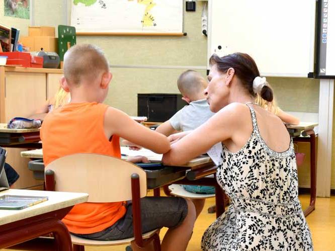 Woman is helping young child with school work
