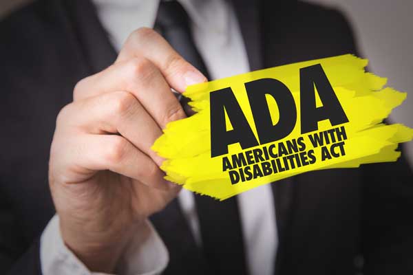 guy in business suit holding yellow sticky note saying americans with disabilities act.