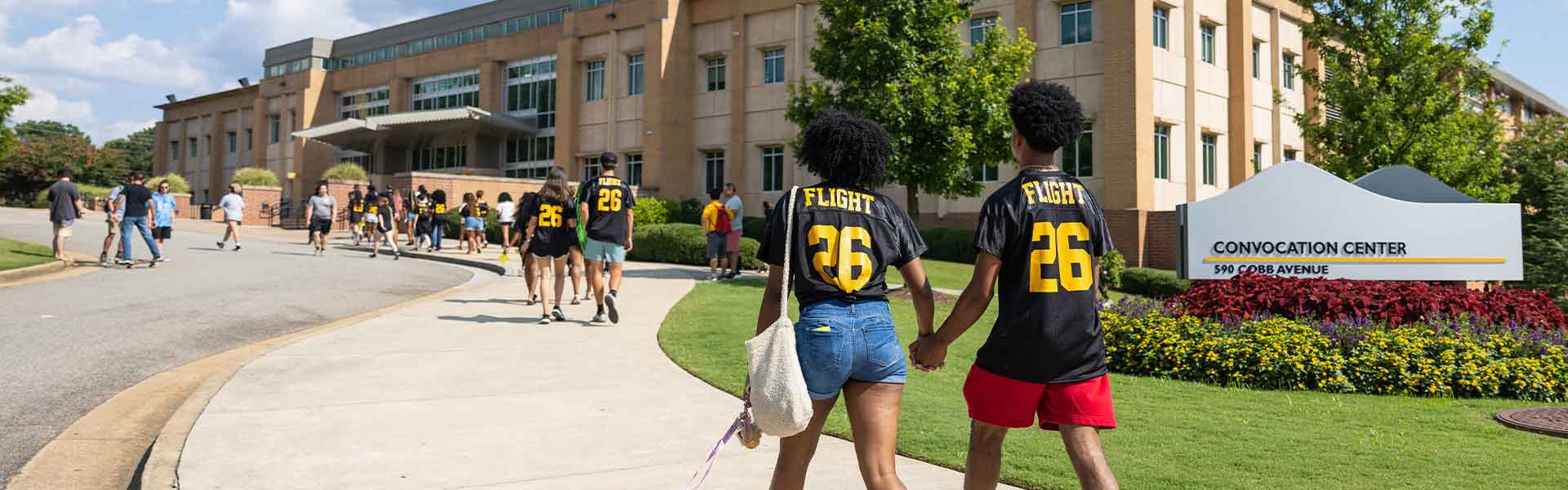 students in FLIGHT26 jerseys walking on campus