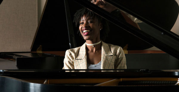  At the Geer College of The Arts, a student expresses joy while playing the piano, highlighting her musical talent and enthusiasm.