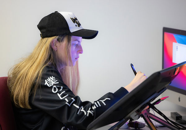 student drawing on large tablet