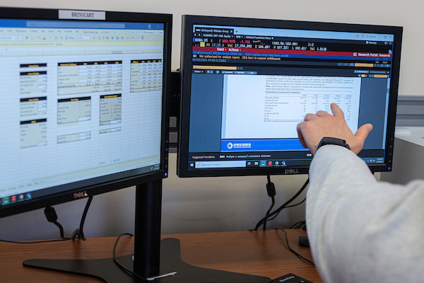 hand pointing to data on computer screen