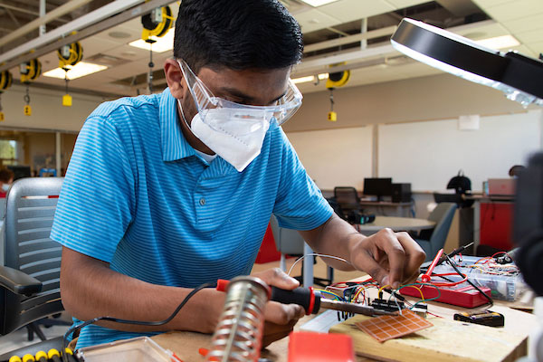 student working on engineering project with solder iron