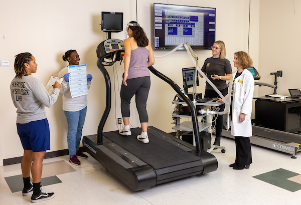 ES students with student on exercise machine