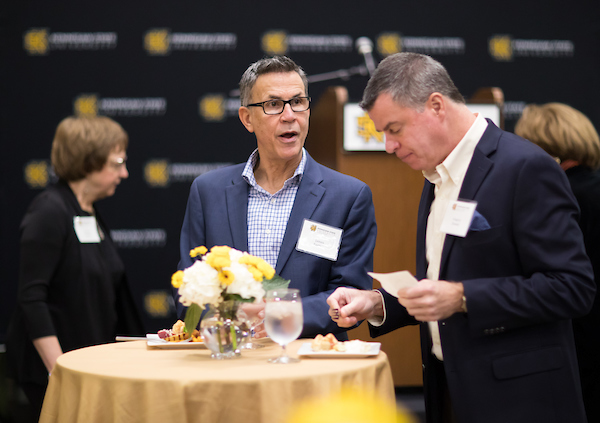 two men standing at a small confernce table