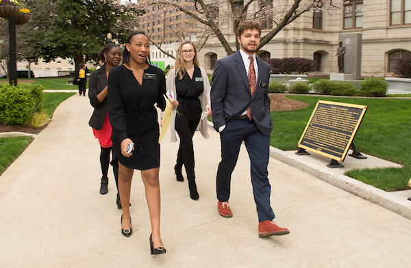 political science students wearing suits walking on campus