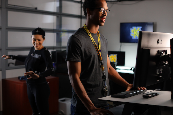 student standing in front of a computer