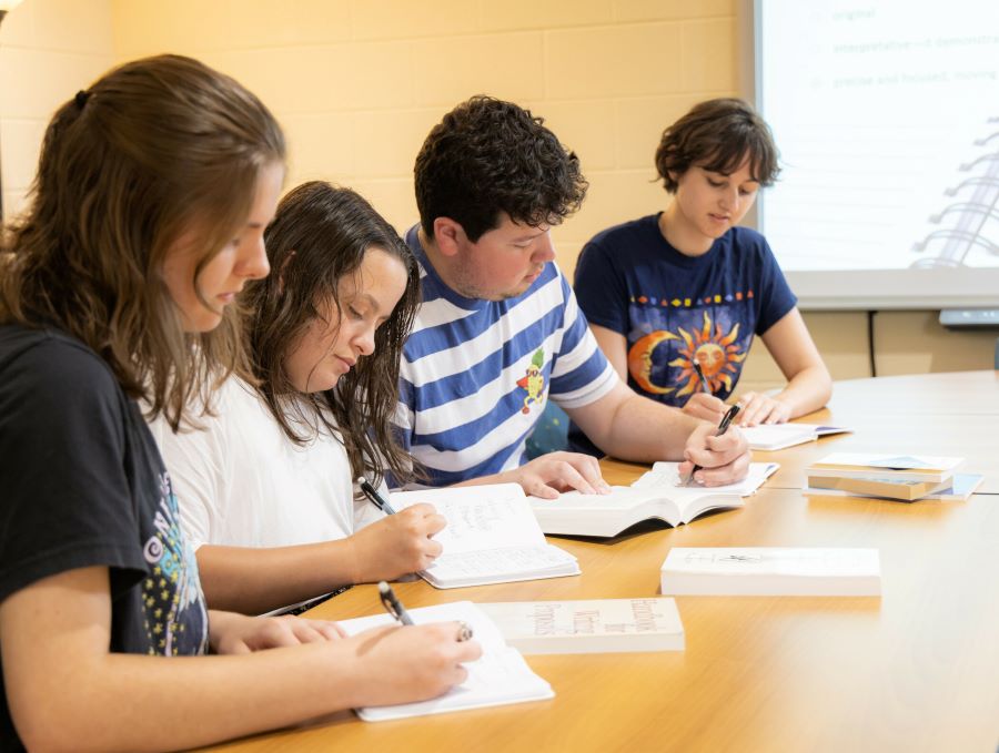Students focused on writing assignments in a classroom setting.