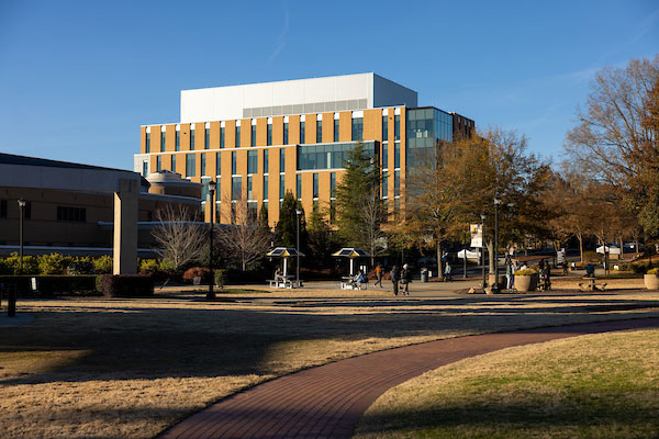 A photo of KSU Academic Learning Center, showcasing a large building during sunset in late fall