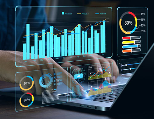 A person's hands interacting with a laptop, with various data visualizations and charts appearing on the screen, including bar graphs, pie charts, and line graphs. The word &quot;AI&quot; is visible, suggesting the use of artificial intelligence in data analysis.