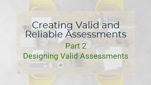 A top-down view of a conference table with a laptop, keyboard, mouse, pens, and papers scattered across it. The text "Creating Valid and Reliable Assessments" and & "Part 2 - Designing Valid Assessments" is written on the table. Two yellow chairs are visible on either side of the table.