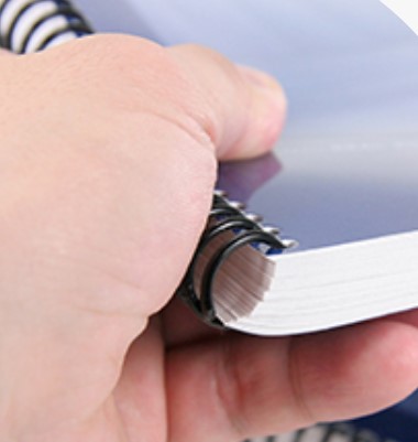 hand holding a spiral notebook.