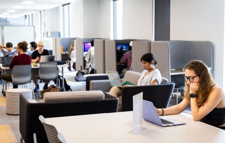 People working on laptops in a modern office space on the KSU campus