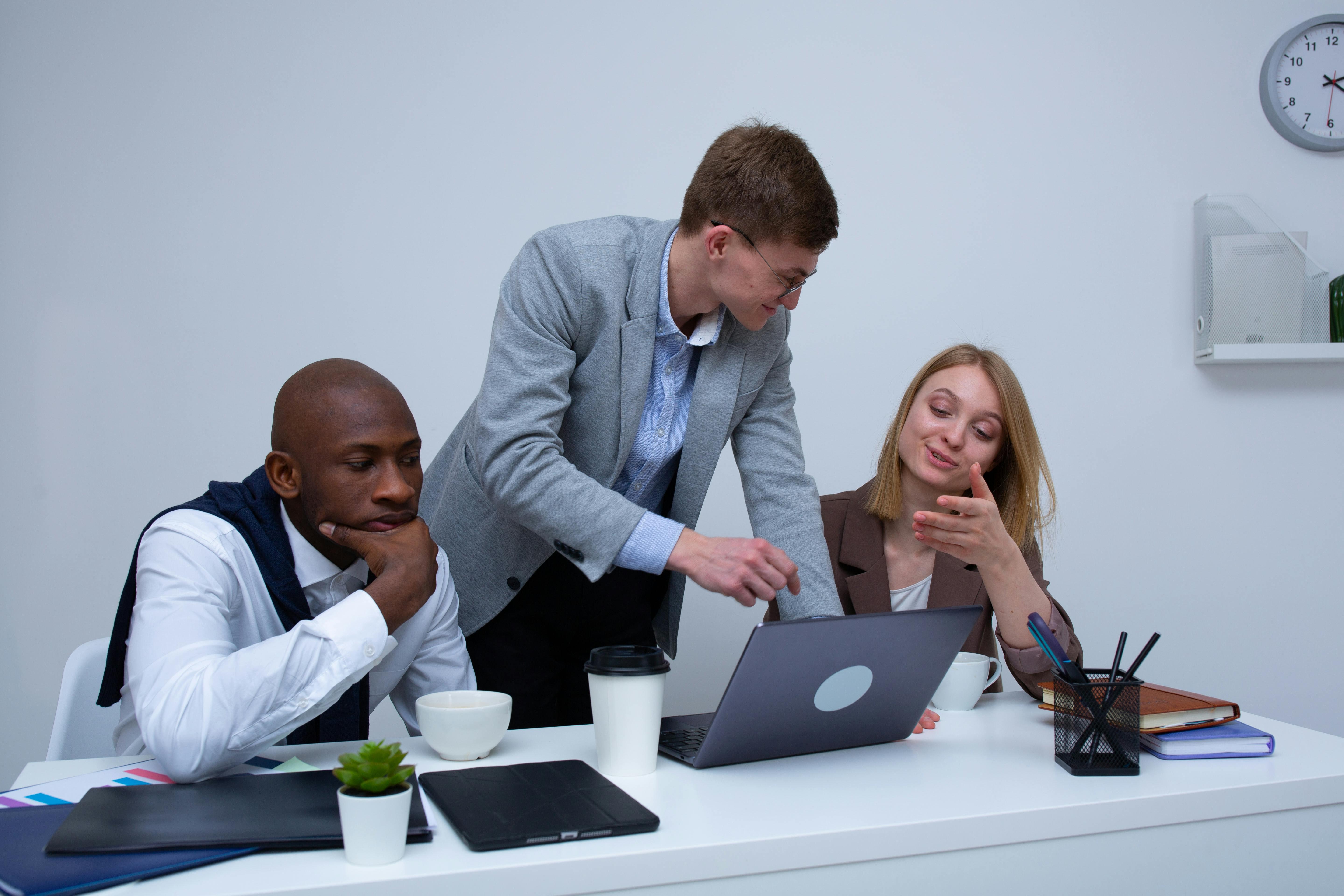group of male and female workers having a discussion at office desk