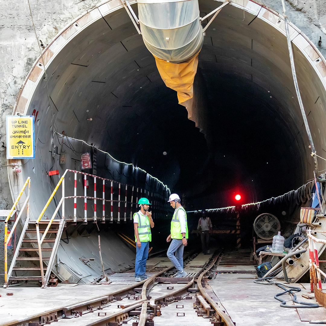 group of two civil engineers talking under a bridge