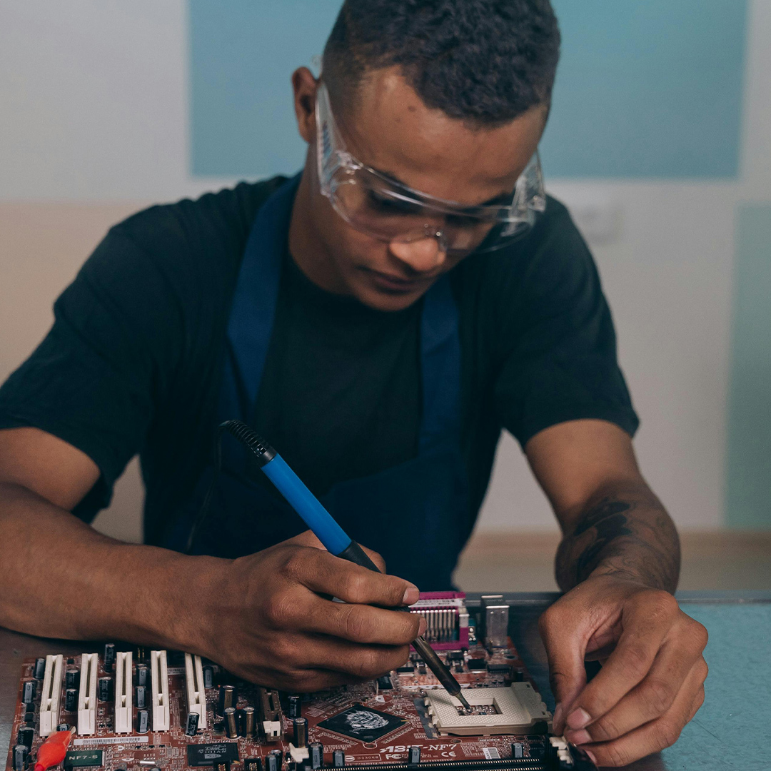male computer engineer with glasses looking down at mechanics