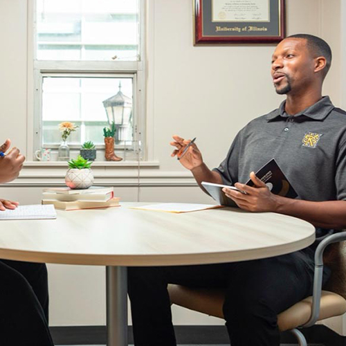 male academic advisor talking to student