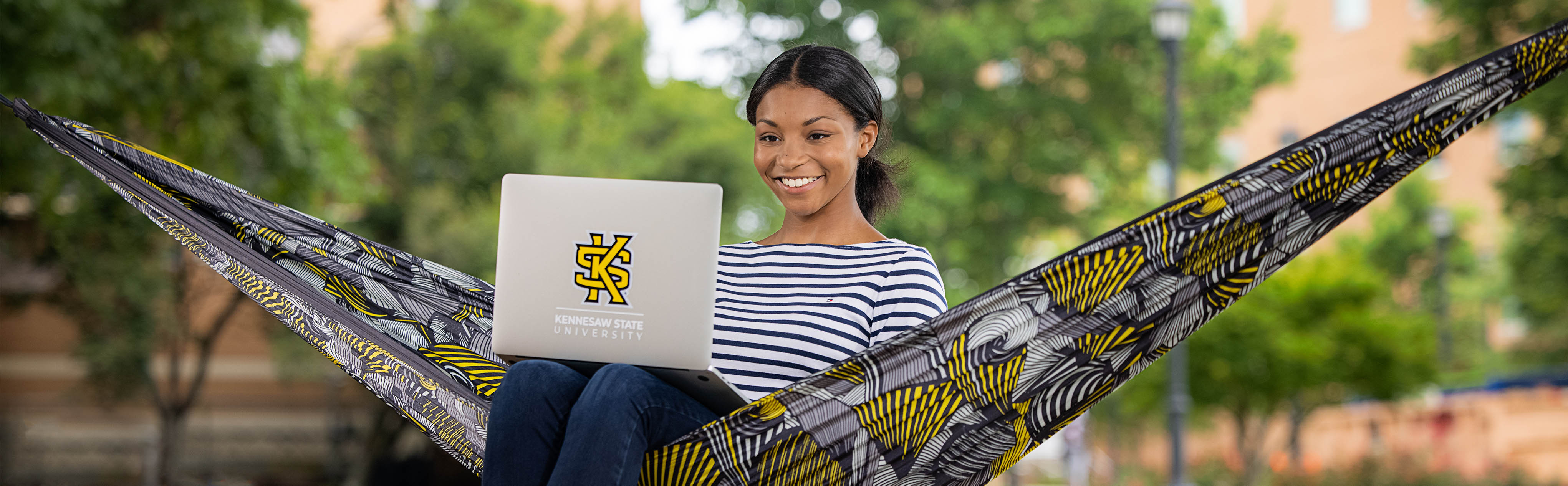 ksu female student sitting outside on computer