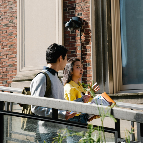 two students walking outside of building