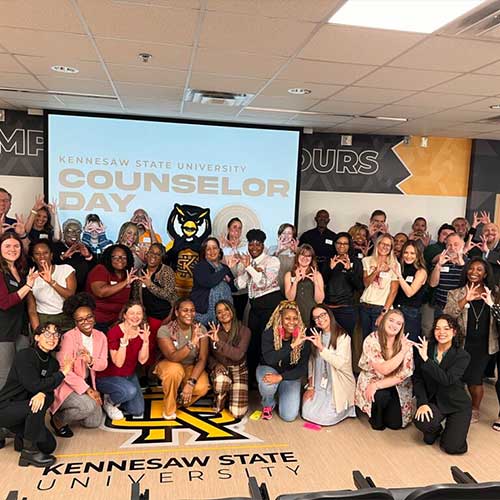 large group of counselors smiling for picture with scrappy.