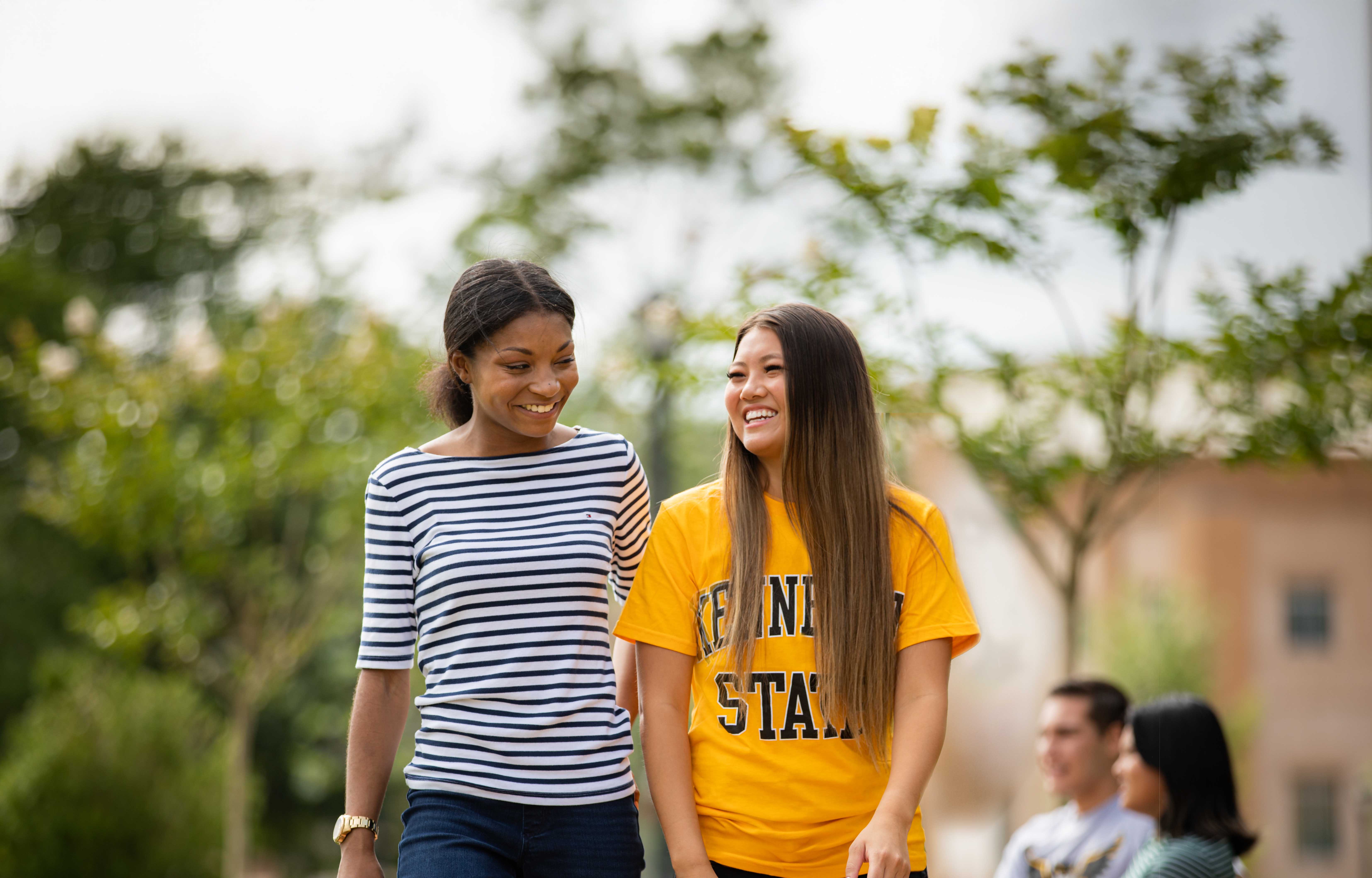 two female ksu students smiling and walking to class