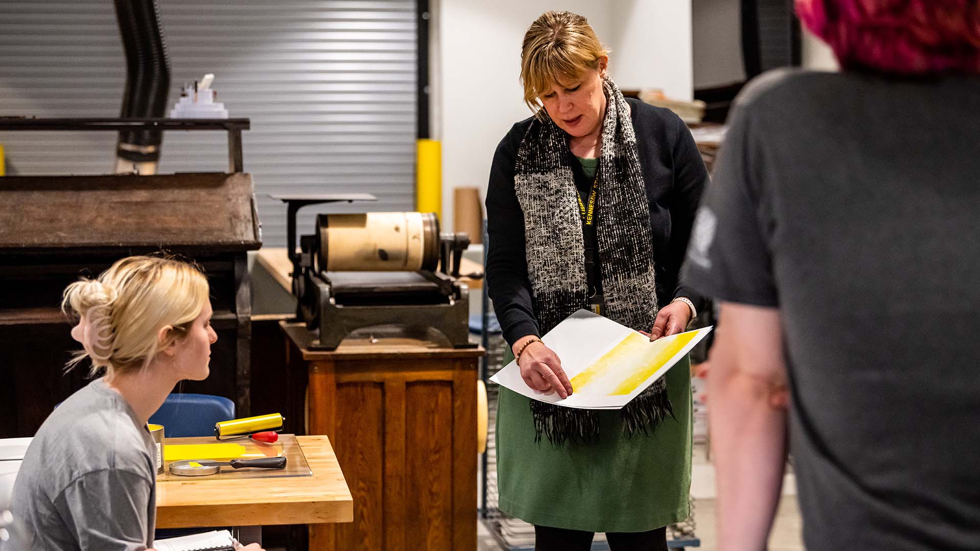  / Professor Cynthia Lollis discussing printmaking with students. 