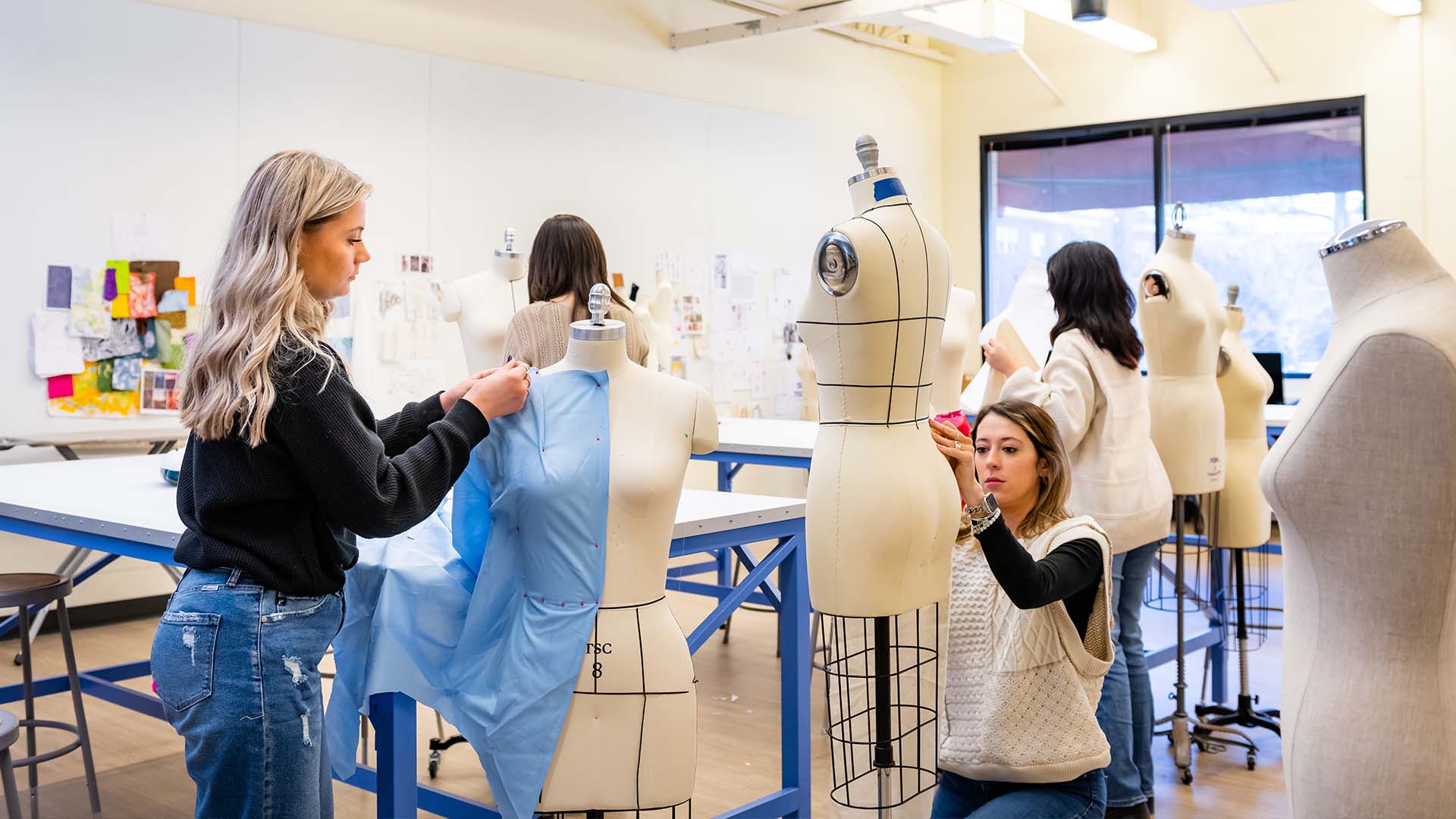  / Textiles students draping mannequins with fabric in textile studio. 