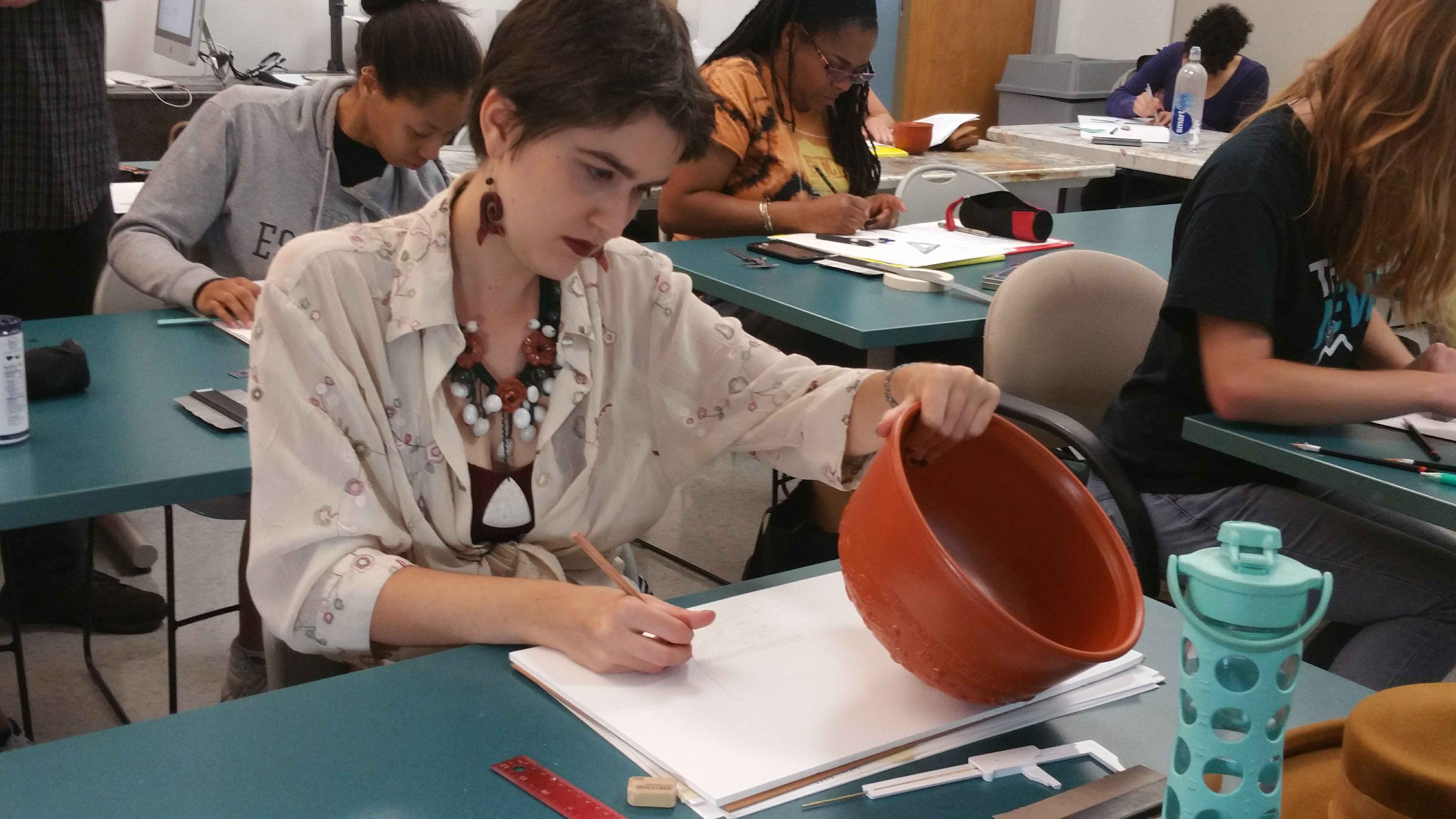  / Student drawing archeological illustration using Roman Pottery. 