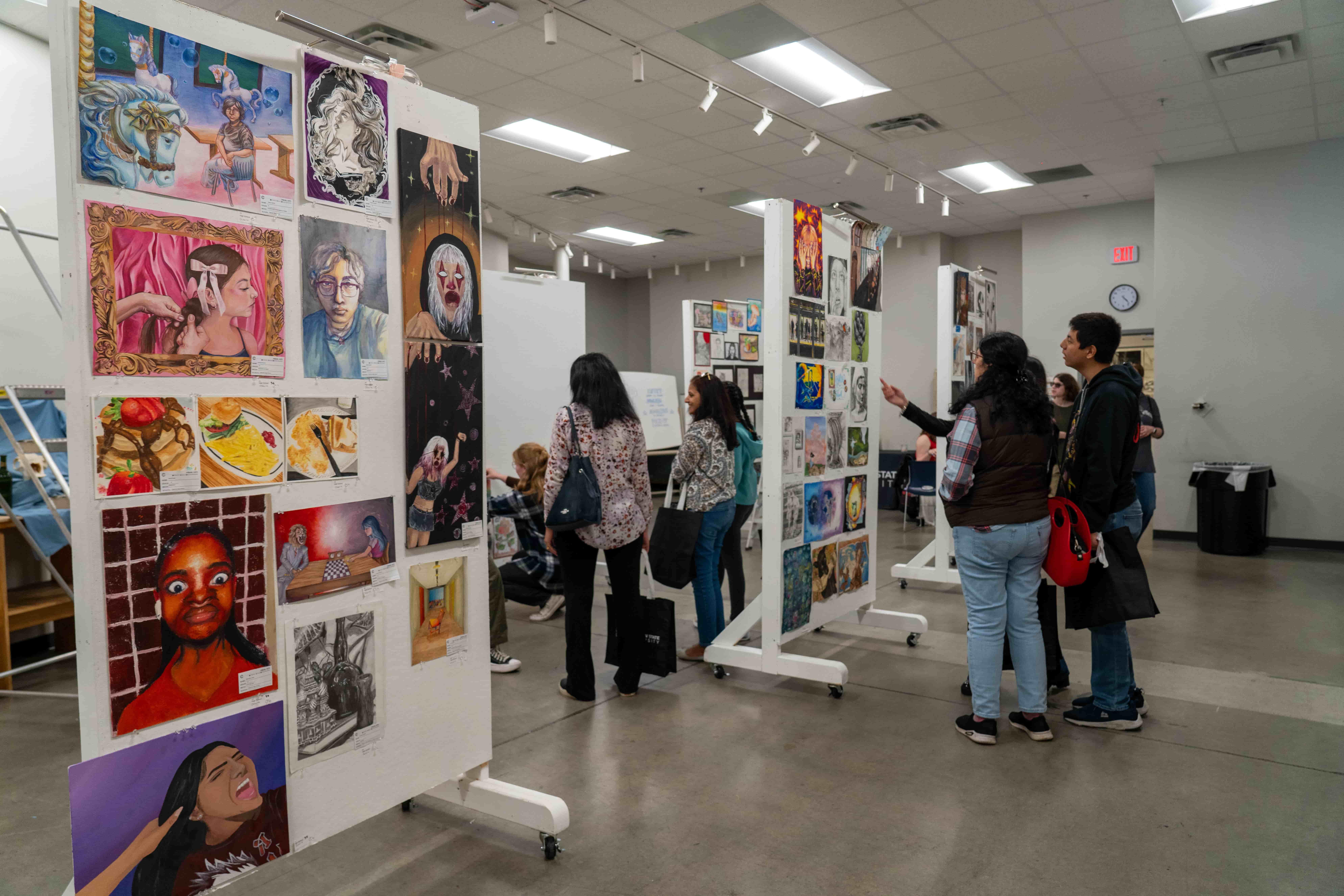 / Guests viewing the various artworks on display at the Art Show