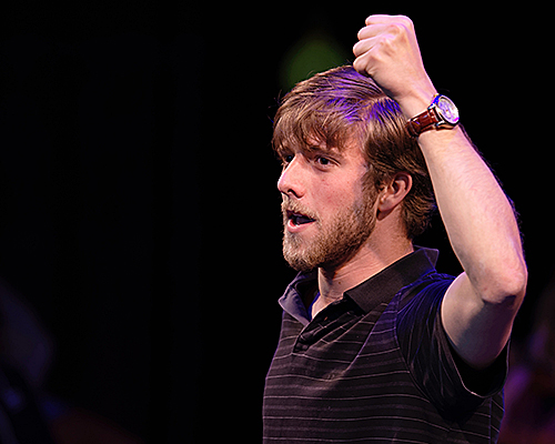 image of man on stage with his arm above his head