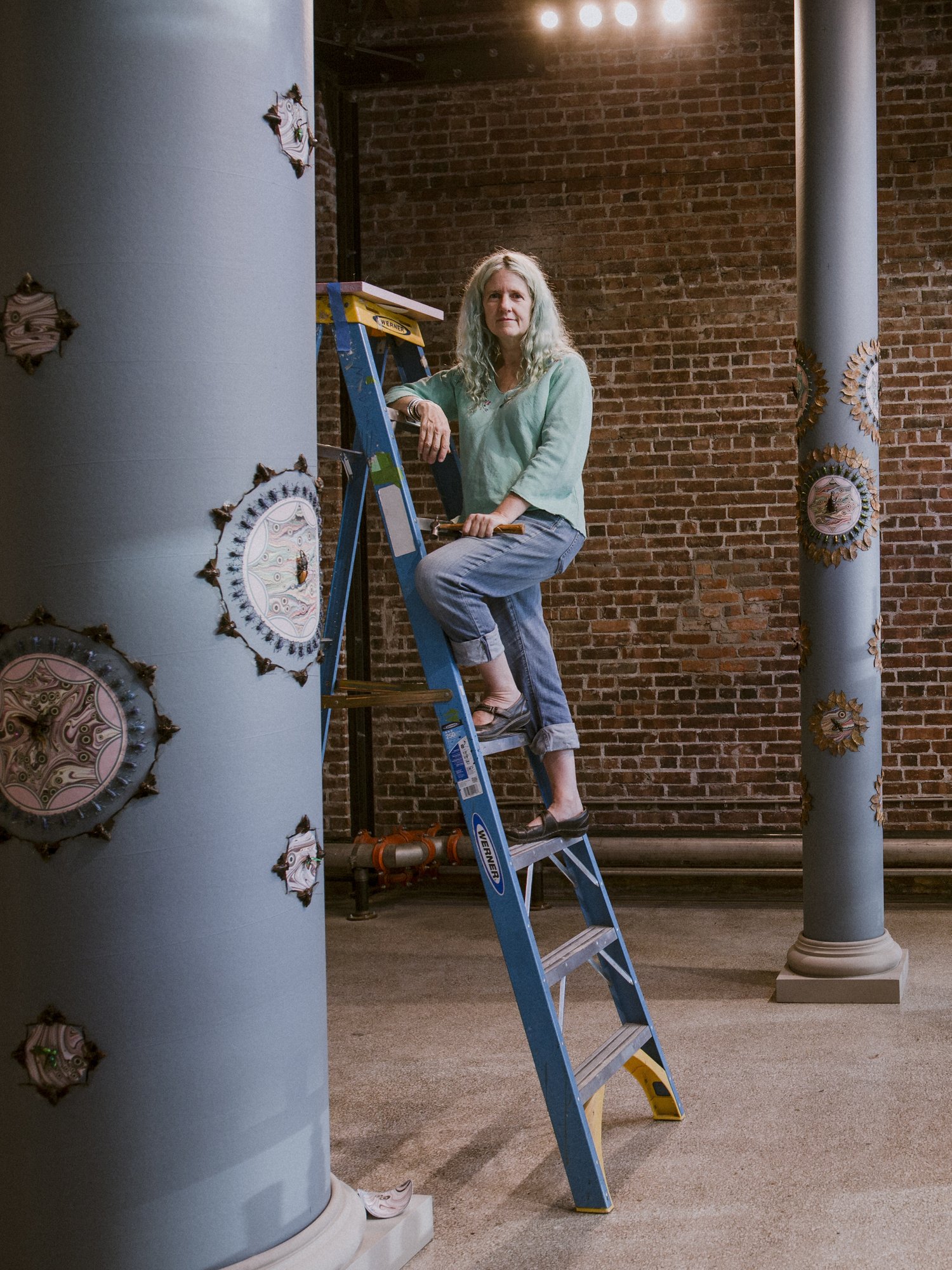 headshot of woman standing on a ladder