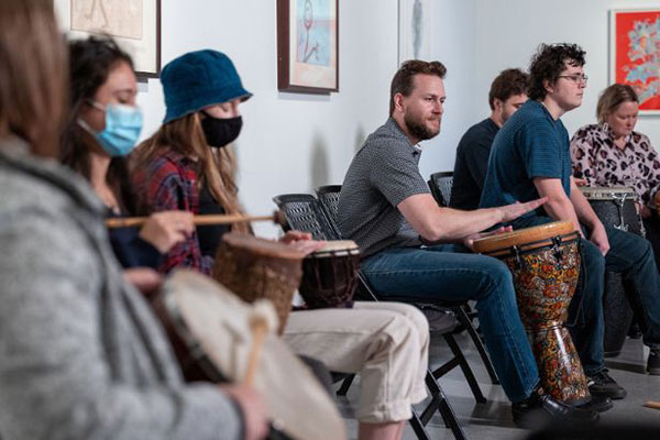 man drumming with people around him
