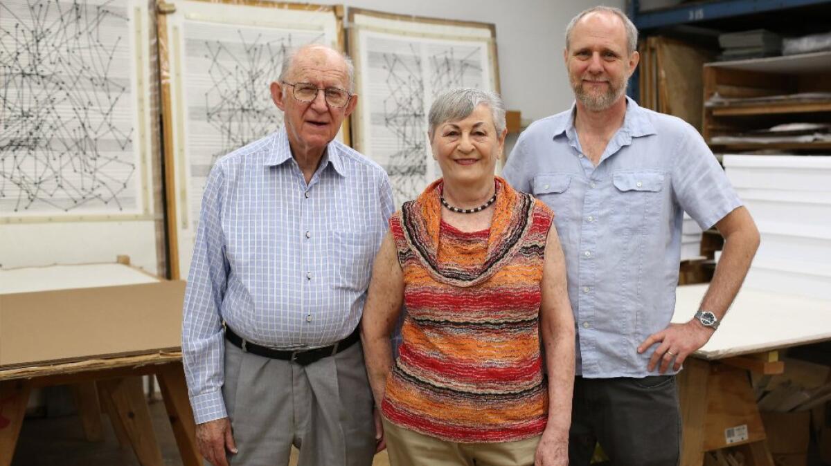 a woman standing alongside two men