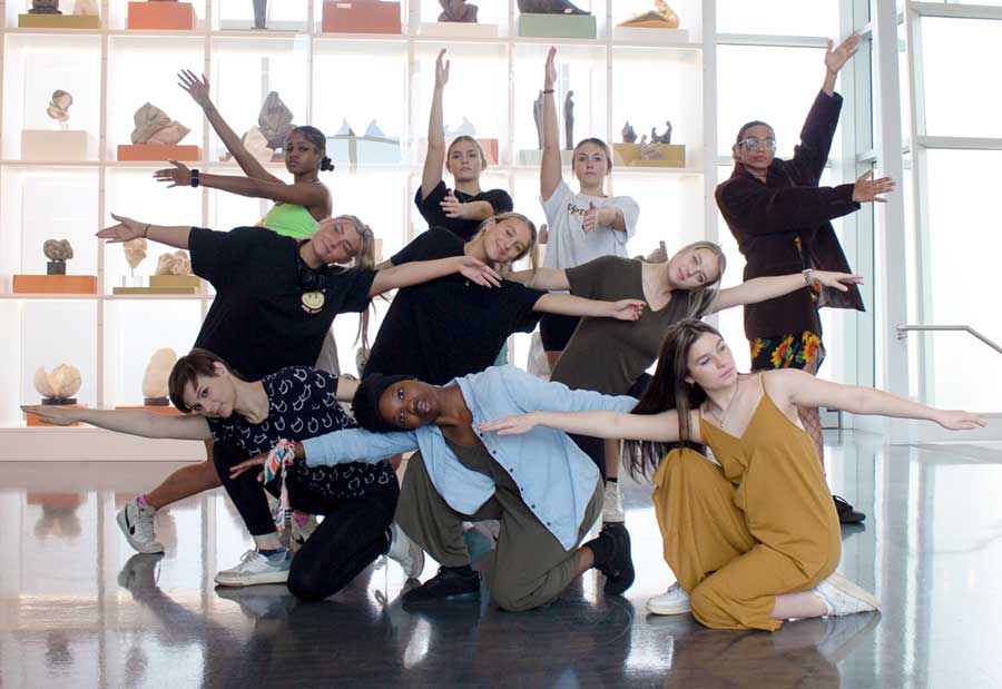 dancers in choreography one class in group formation with arms extended in every direction