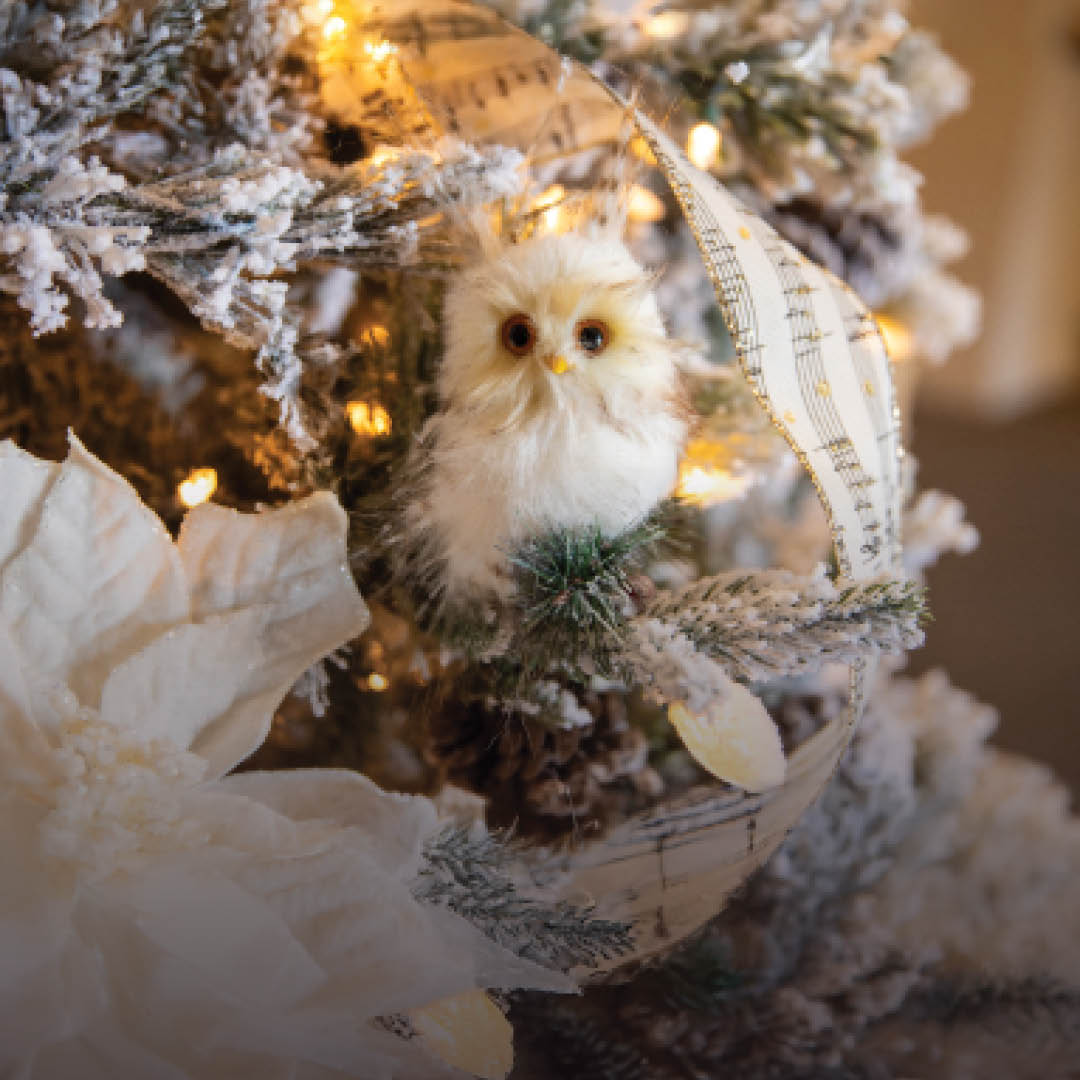 a small snowy owl decoration on a Christmas tree