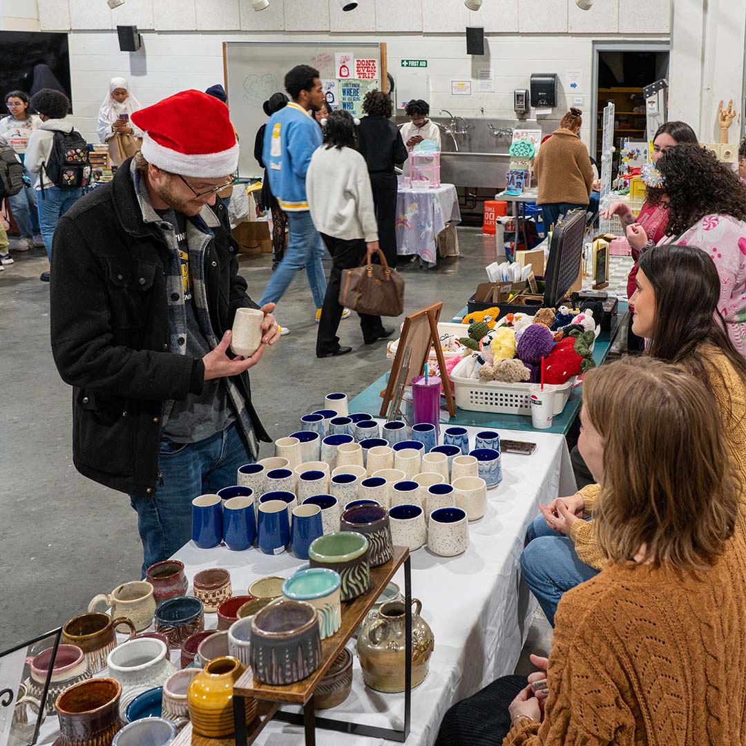 man shopping pottery made by students