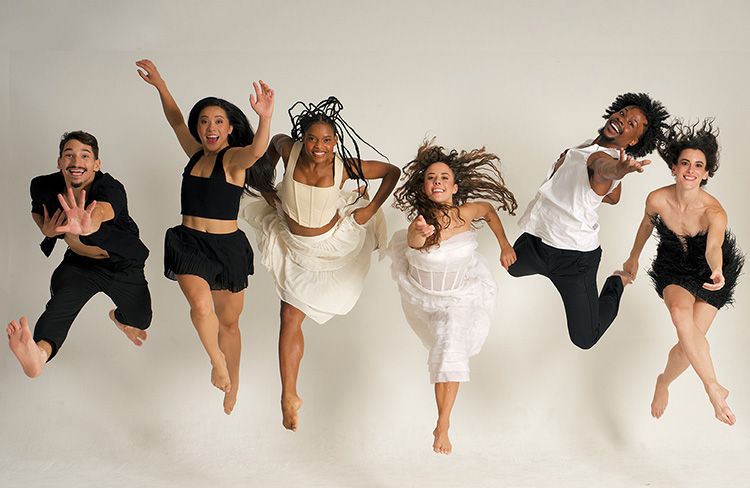 bodytraffic dancers smiling dressed in black and white and reaching to the camera