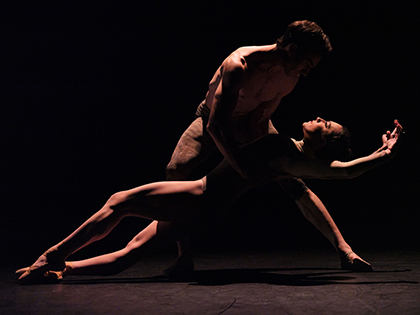 two dancers entwined in an embrace on stage