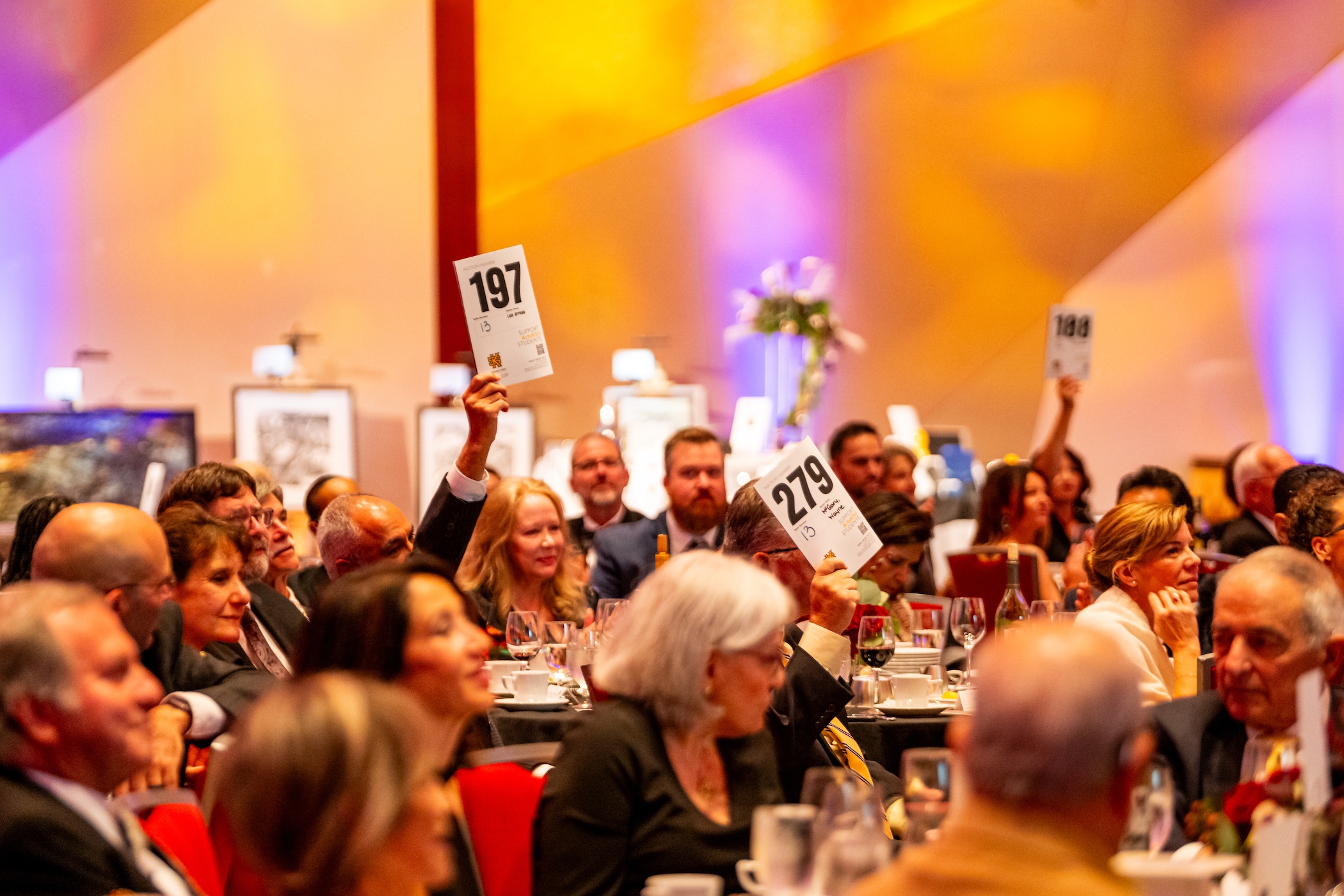 guests raise paddles at the 2025 ArtsKSU Gala