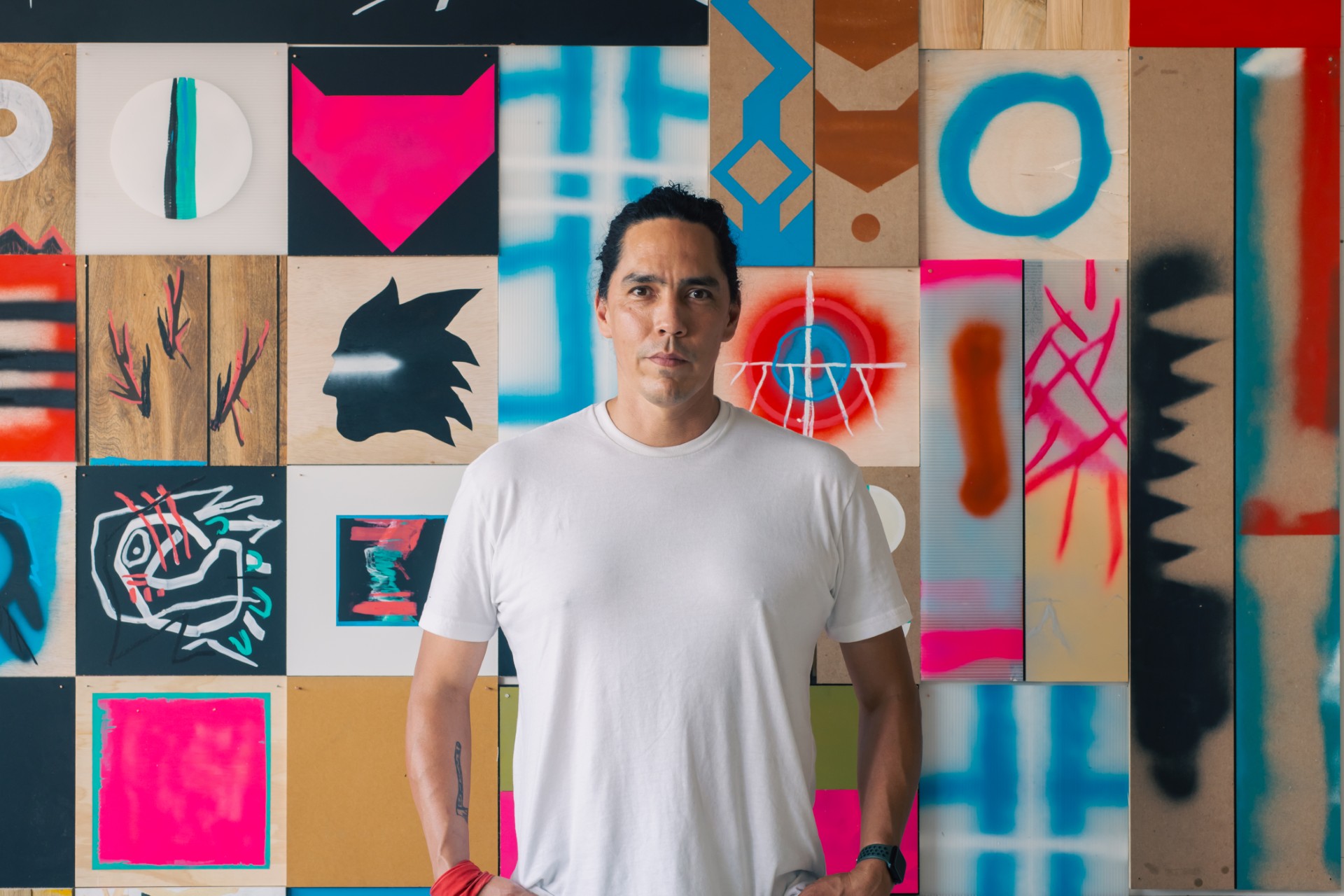 artist matthew kirk standing in front of his colorful artwork