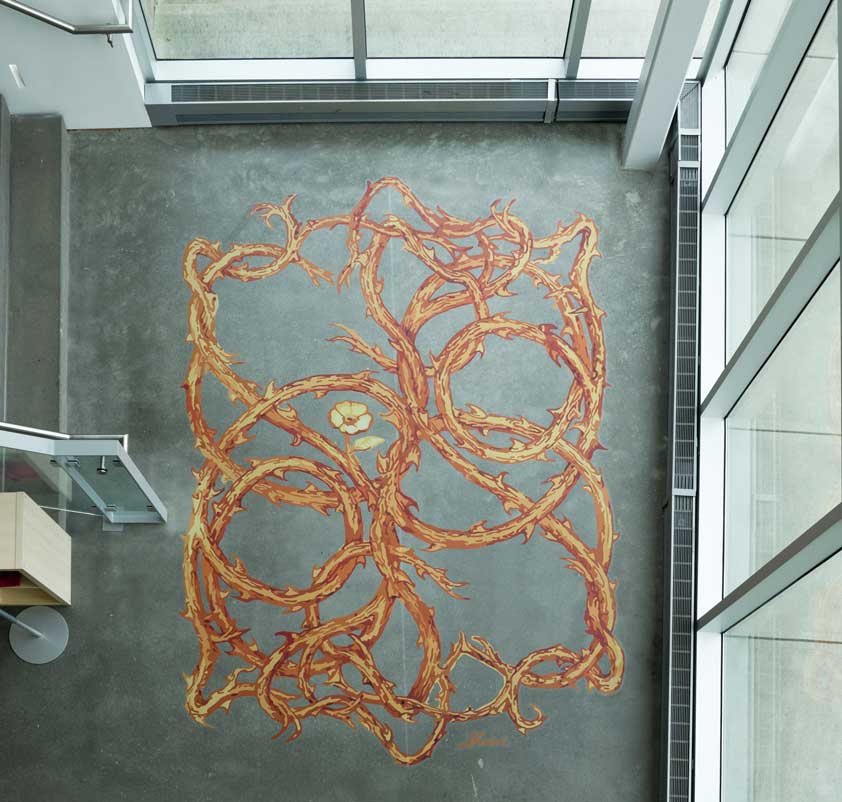 Installation view of Robert Sherer's vinyl graphic at ZMA. Stronghold consists of several drawing of vinyls interlacing together. The vines are warm in color, shades of burnt orange, yellows, and rusty reds.