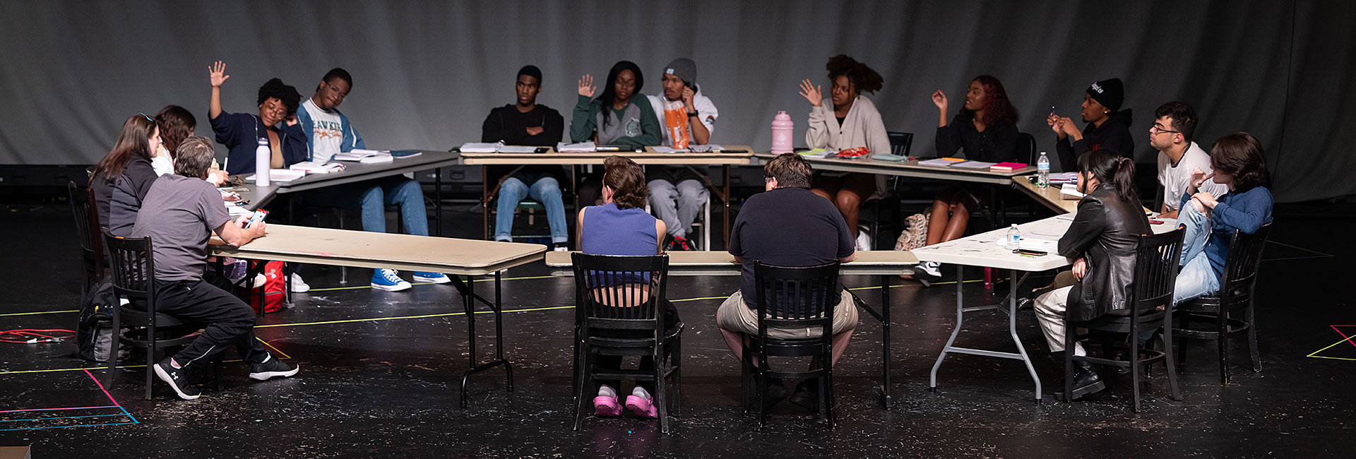 theatre students sit around the table during the production of rent