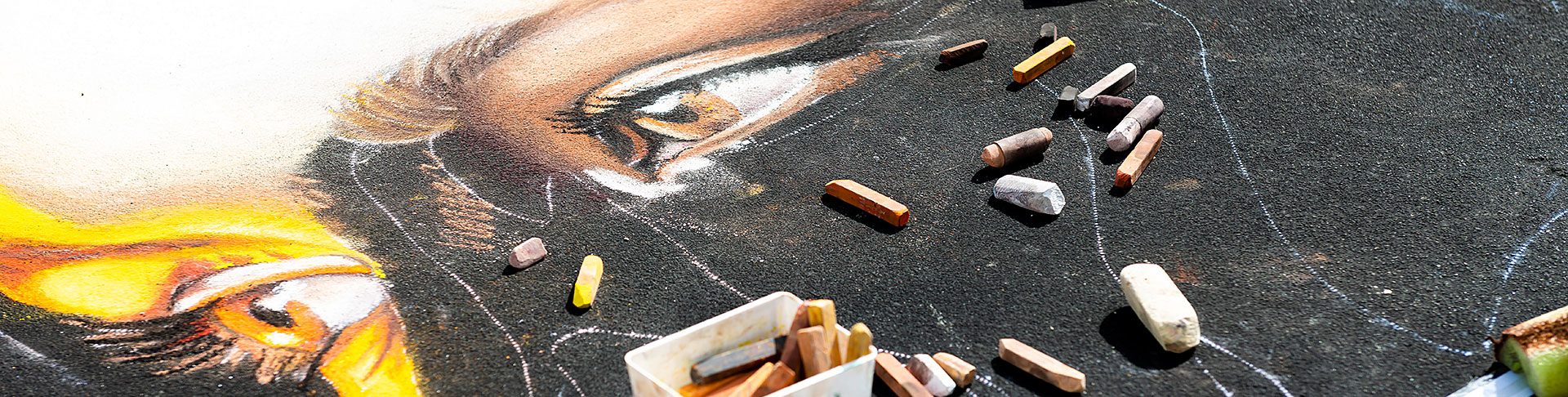 chalk scattered over half eye drawn on asphalt