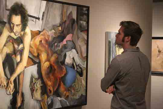 man looking at painting