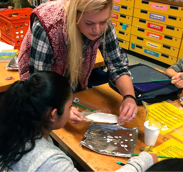 student completes her acrylic painting on the raised portions of her zellij project