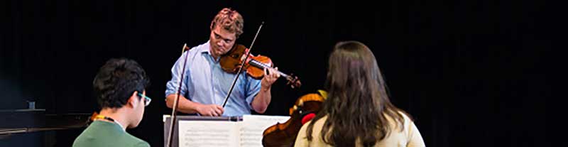 David Coucheron playing violin with students