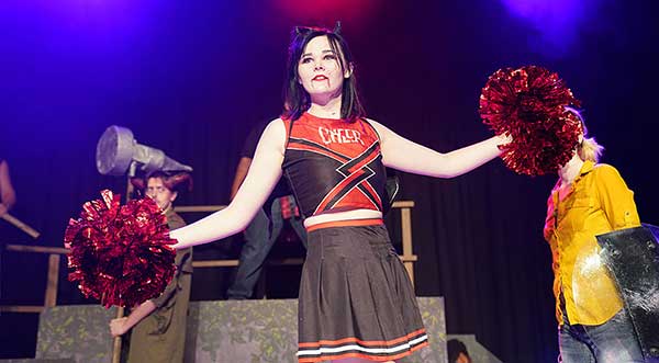 image of jess ford on stage in cheerleader costume