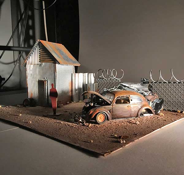 set design model of junked vw bug in yard