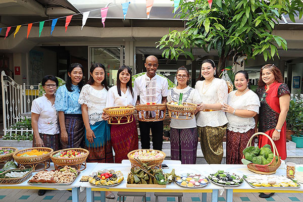 image of Kenny Davis in Thailand over a buffet table of food, with lots of friends